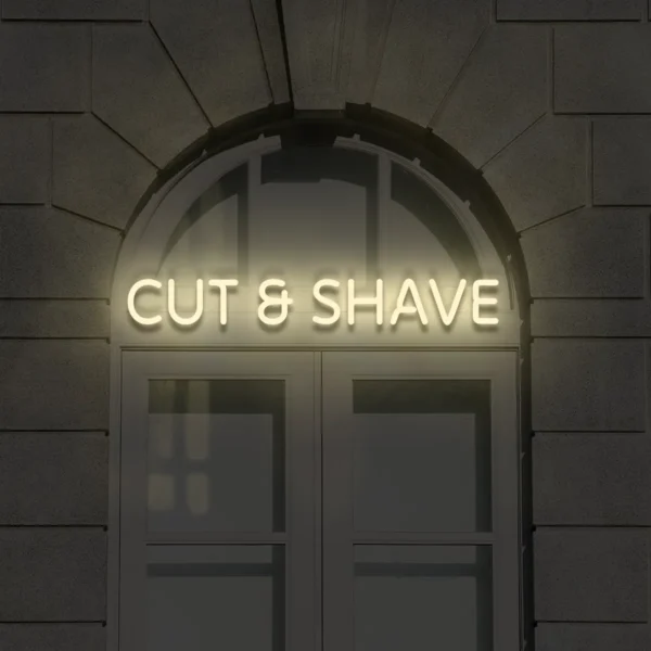 Beżowy neonowy napis Cut & Shave na elewacji nad wejściem