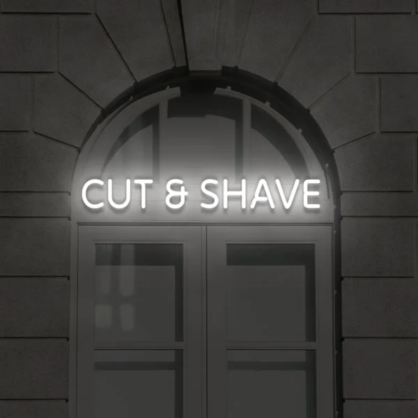 Biały neon LED z napisem Cut & Shave na ścianie fasady