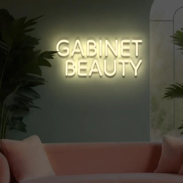Neonowy napis „Gabinet Beauty” w kolorze beżowym na ścianie salonu