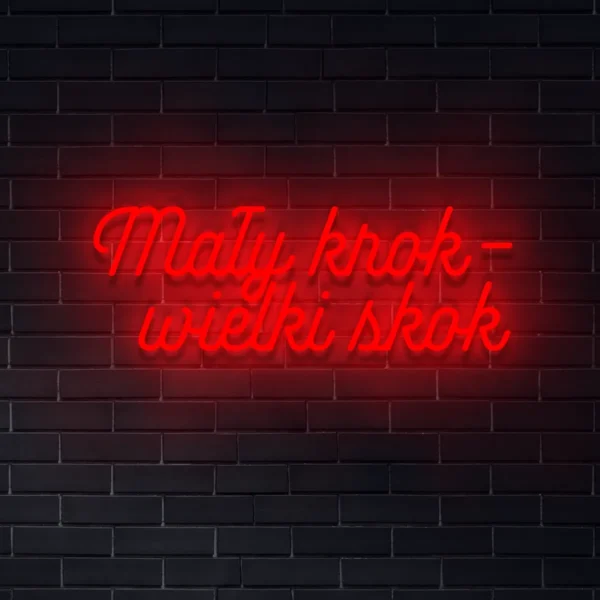 Czerwony neon LED „Mały krok – wielki skok” na ceglanej ścianie