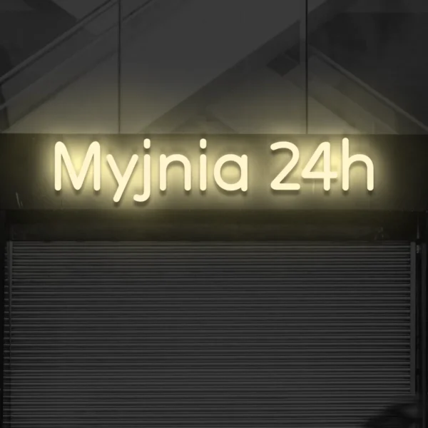 Beżowy neonowy napis Myjnia 24h na elewacji