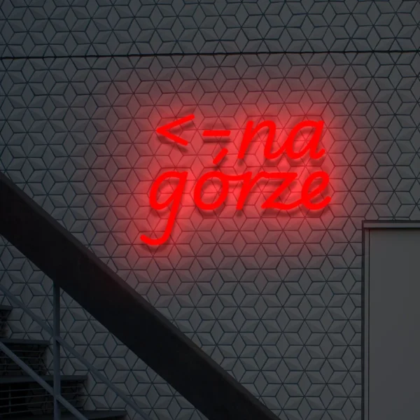 Czerwony neon „na górze” szyld informacyjny ze strzałką