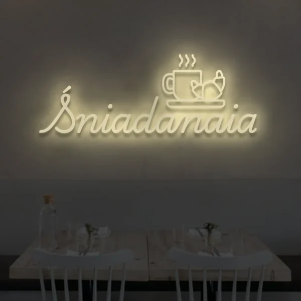 Neonowy napis Śniadania w kolorze beżowym z ikoną kawy i rogalika