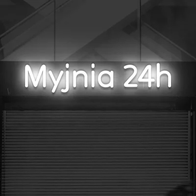 Biały neon LED z napisem Myjnia 24h nad bramą