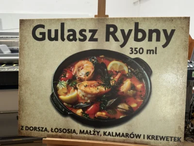 Szyld z daniem „Gulasz rybny”, grafika z zupą rybną na płycie pleksi