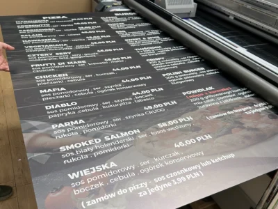 Moment produkcji tablicy menu restauracyjnego z użyciem druku UV na czarnym Dibondzie